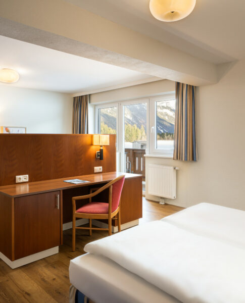 Ein großes Doppelbett in den Familienzimmern im elaya hotel steinplatte