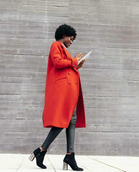 Stylish woman using a digital tablet while walking outdoors on the street. Die Tagungsräume in den elaya hotels.