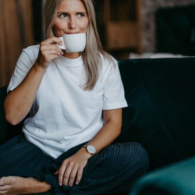 model-am-sessel-junior-suite-elaya-hotel-villach Frau trink Kaffee im elaya hotel villach