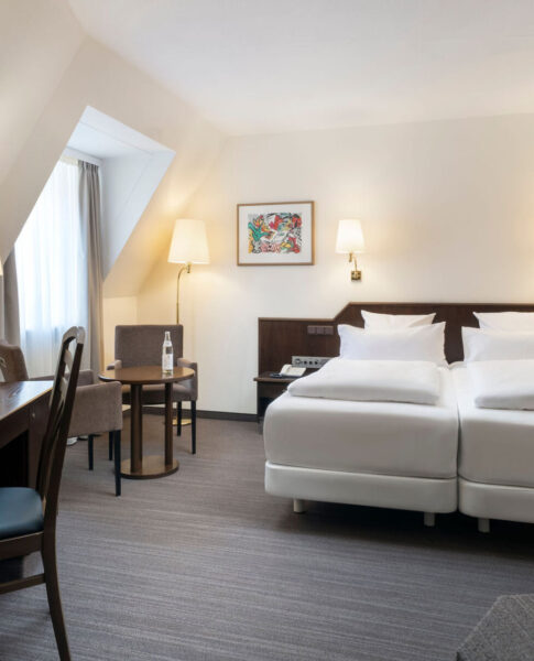 elaya-hotel-noerdlingen-standard-doppelzimmer-bett Unser Doppelzimmer verfügt über eine Sitzecke und einen Schreibtisch