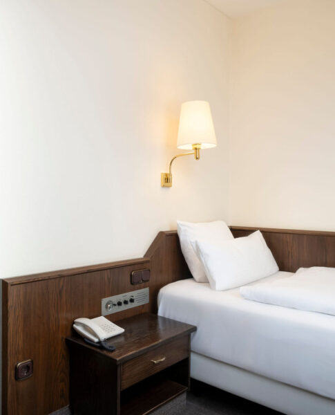 elaya-hotel-noerdlingen-standard-einzelzimmer-bett Das Bett im Einzelzimmer